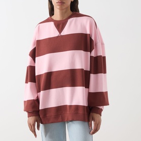 Model wearing Free People V-Insert Striped Sweater in Strawberry Wine Comb, bold pink and burgundy stripes, crew neck, oversized fit, styled with