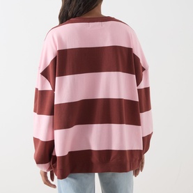 Model wearing Free People V-Insert Striped Sweater in Strawberry Wine Comb, bold pink and burgundy stripes, dropped shoulders, rear view