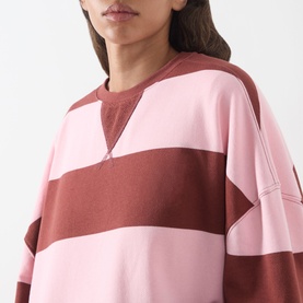 Model wearing Free People V-Insert Striped Sweater in Strawberry Wine Comb, showing crew neck V-insert detail and wide stripes