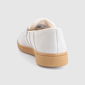 Adidas trainer in Wonder White with textured upper, three-stripe detail, and honey gum rubber sole, rear three-quarter view.