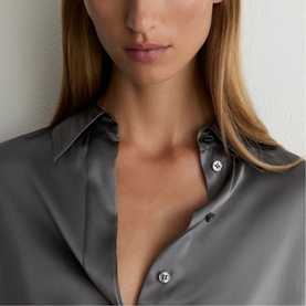Model wearing Reiss dark grey satin shirt dress, close-up detail of collar and button placket