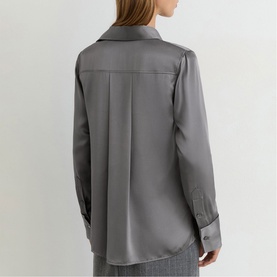 Model wearing Reiss dark grey satin-finish shirt, back view showing box pleat detail and cuffed long sleeves, styled with matching trousers.