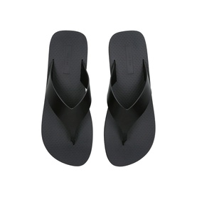 THE ROW Ginza Leather Slides in black, flip-flop style with thong strap, flat rubber sole, overhead view