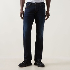 Model wearing Diesel 2007 Zatiny Bootcut Jeans in dark blue with dark wash finish, styled with black leather shoes.