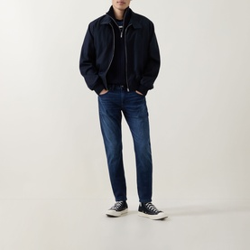 Model wearing Diesel 3049 dark blue skinny jeans, styled with a navy bomber jacket, black zip top and black high-top trainers.