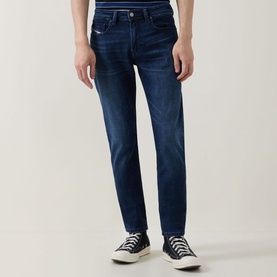 Model wearing Diesel 3049 dark blue skinny jeans with subtle fading, styled with a white tee and white canvas trainers.