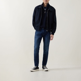 Model wearing Diesel 3049 dark blue skinny jeans, styled with a navy bomber jacket and black high-top trainers.