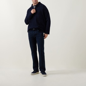 Model wearing Diesel 3049 slim jeans in dark blue, styled with a navy zip-up sweatshirt and grey trainers.
