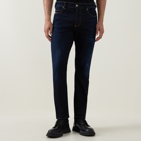 Model wearing Diesel 3049 slim jeans in dark blue denim, styled with black leather lace-up shoes
