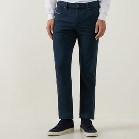 Model wearing Diesel 1993 D-VYL Slim-Leg Jeans in blue, dark wash, slim fit, styled with white shirt and navy suede shoes