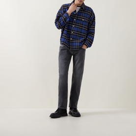 Model wearing Diesel 3049 dark grey straight jeans, styled with blue plaid overshirt and black leather shoes.