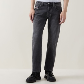Model wearing Diesel 3049 dark grey straight jeans, styled with black leather boots, relaxed fit with faded wash detail
