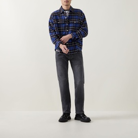 Model wearing Diesel 3049 dark grey straight jeans, styled with a blue plaid overshirt and black chunky loafers.