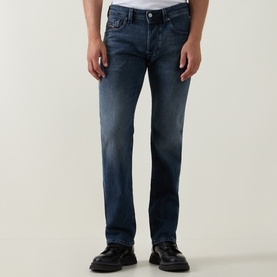 Model wearing Diesel 3049 straight jeans in dark blue denim with faded wash detail, styled with black leather shoes.