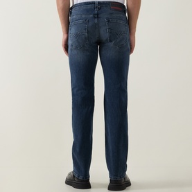 Model wearing Diesel 3049 dark blue straight jeans, rear view showing back pockets and slight fade detail, styled with dark shoes.