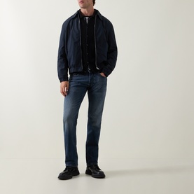 Model wearing Diesel 3049 straight jeans in dark blue, styled with a navy bomber jacket and black shoes.