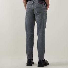 Model wearing Diesel 3049 grey tapered jeans, rear view, styled with black leather shoes