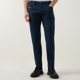 Model wearing Diesel 3049 blue tapered jeans in cotton blend, styled with black leather lace-up boots