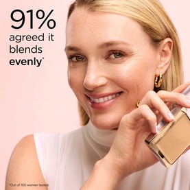 Model with Elizabeth Arden Flawless Finish Sponge-On Cream Makeup in Gentle Beige, holding compact foundation close to face, smiling