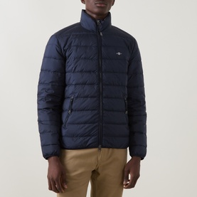 Model wearing Gant Evening Blue quilted down casual jacket with funnel neck and zip chest pocket, styled with tan trousers.