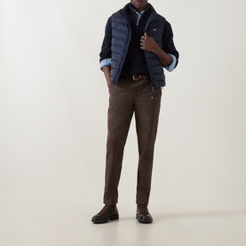 Model wearing Gant Evening Blue quilted down gilet, styled with navy knitwear, light blue shirt, and brown trousers.