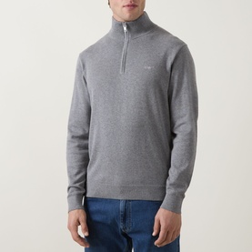 Model wearing Gant Shield Logo Half-Zip Sweatshirt in dark grey melange, funnel neck, ribbed trims, styled with blue jeans.