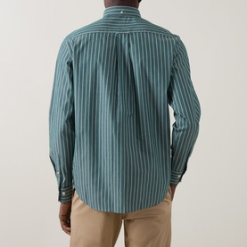 Model wearing Gant Reg Shirt in dark emerald with white vertical stripes, rear view, styled with beige chinos.