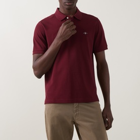 Model wearing Gant Regular Polo in Deep Grape Wine, short-sleeved piqu&eacute; cotton with logo embroidery, styled with stone chinos.