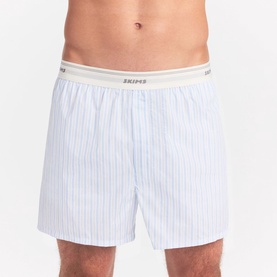Model wearing Skims Boxers 1Pk in Platinum Double Stripe, white woven fabric with thin stripes and branded elastic waistband