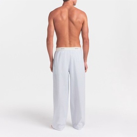 Model wearing Skims Pyjama Bottom in Platinum Double Stripe, shown from behind, wide-leg fit with logo waistband.