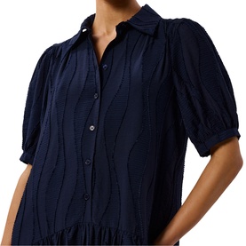 Model wearing Whistles blue textured button-front dress with puff sleeves, wave-pattern fabric, and collared neckline