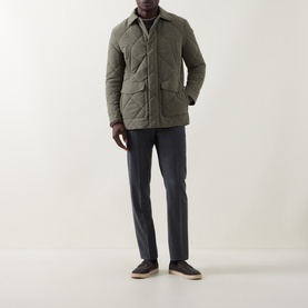 Model wearing Canali Diamond Quilted Field Jacket in green with pointed collar, styled with navy trousers and taupe suede loafers.