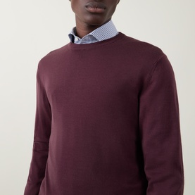 Model wearing Canali Fine-Knit Sweater in burgundy wool with crew neck, styled over a blue striped shirt.