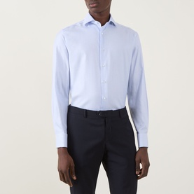 Model wearing Canali Textured Double-Cuff Shirt in blue, cutaway collar, long sleeves, styled with navy trousers.