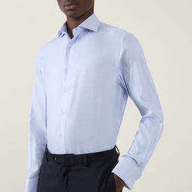Model wearing Canali Textured Double-Cuff Shirt in blue with cutaway collar, long sleeves and double cuffs, styled with navy trousers.