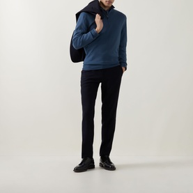 Model wearing Canali blue wool half-zip knitwear, styled with dark trousers and black shoes, carrying a bag over shoulder.