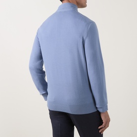 Model wearing Canali Merino Half-Zip Sweater in light blue, showing rear view with funnel neck and fine knit detail, styled with navy trousers.
