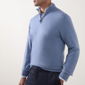 Model wearing Canali Merino Half-Zip Sweater in light blue with funnel neck and ribbed trims, styled with navy trousers.