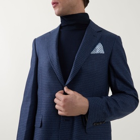 Model wearing Canali dark blue wool-silk blazer with micro check pattern, styled with black roll neck and light blue pocket square.