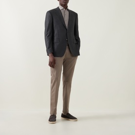 Model wearing Canali Prince Of Wales Check Suit Jacket in charcoal, single-breasted notch lapel, styled with taupe trousers and dark loafers.