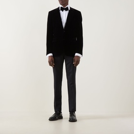 Model wearing Canali D6 Velvet Single-Breasted Suit Jacket in black with bow tie, white shirt, dark trousers and black leather shoes.