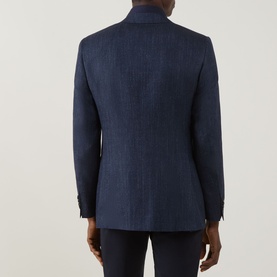 Model wearing Canali D8 Herringbone Single-Breasted Suit Jacket in Navy Nights, rear view showing back seam and rear vents, styled with navy trousers.