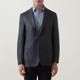 Model wearing Canali D8 Herringbone Single-Breasted Blazer in charcoal, styled with a blue gingham shirt and dark trousers.