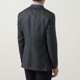 Model wearing Canali D8 Herringbone Single-Breasted Blazer in charcoal, rear view showing double vent and buttoned cuffs, styled with blue check