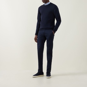 Model wearing Canali Fine-Knit Sweater in black, crew neck, long sleeves, styled with navy trousers and suede trainers.