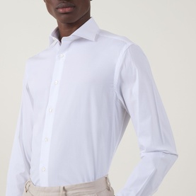 Model wearing Canali Travel Stretch Single-Cuff Shirt in white, cutaway collar, long sleeves, front button placket, styled with beige trousers
