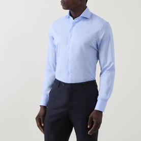 Model wearing Canali Travel Stretch Single-Cuff Shirt in blue with cutaway collar and buttoned cuffs, styled with navy trousers.