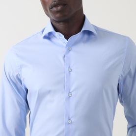 Model wearing Canali Travel Stretch Single-Cuff Shirt in blue, with cutaway collar and front button placket visible.