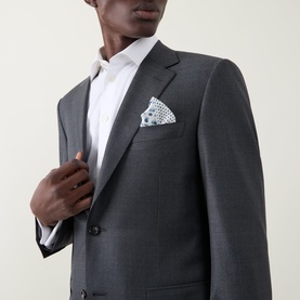 Model wearing Canali Drop 6 Griz Two-Piece Suit in grey wool, single-breasted notch lapel jacket with white pocket square and shirt.