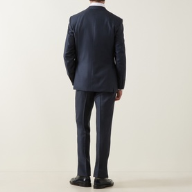 Model wearing Canali D6 Griz Solid Two-Piece Suit in dark blue, rear view showing single-breasted jacket with rear vents and slim-leg trousers.